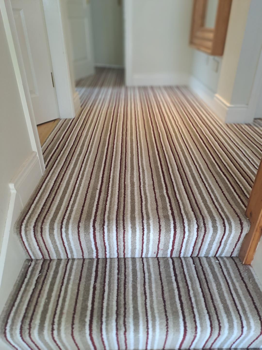 Soft stripped carpet fitted on stairs running upstairs through the landing